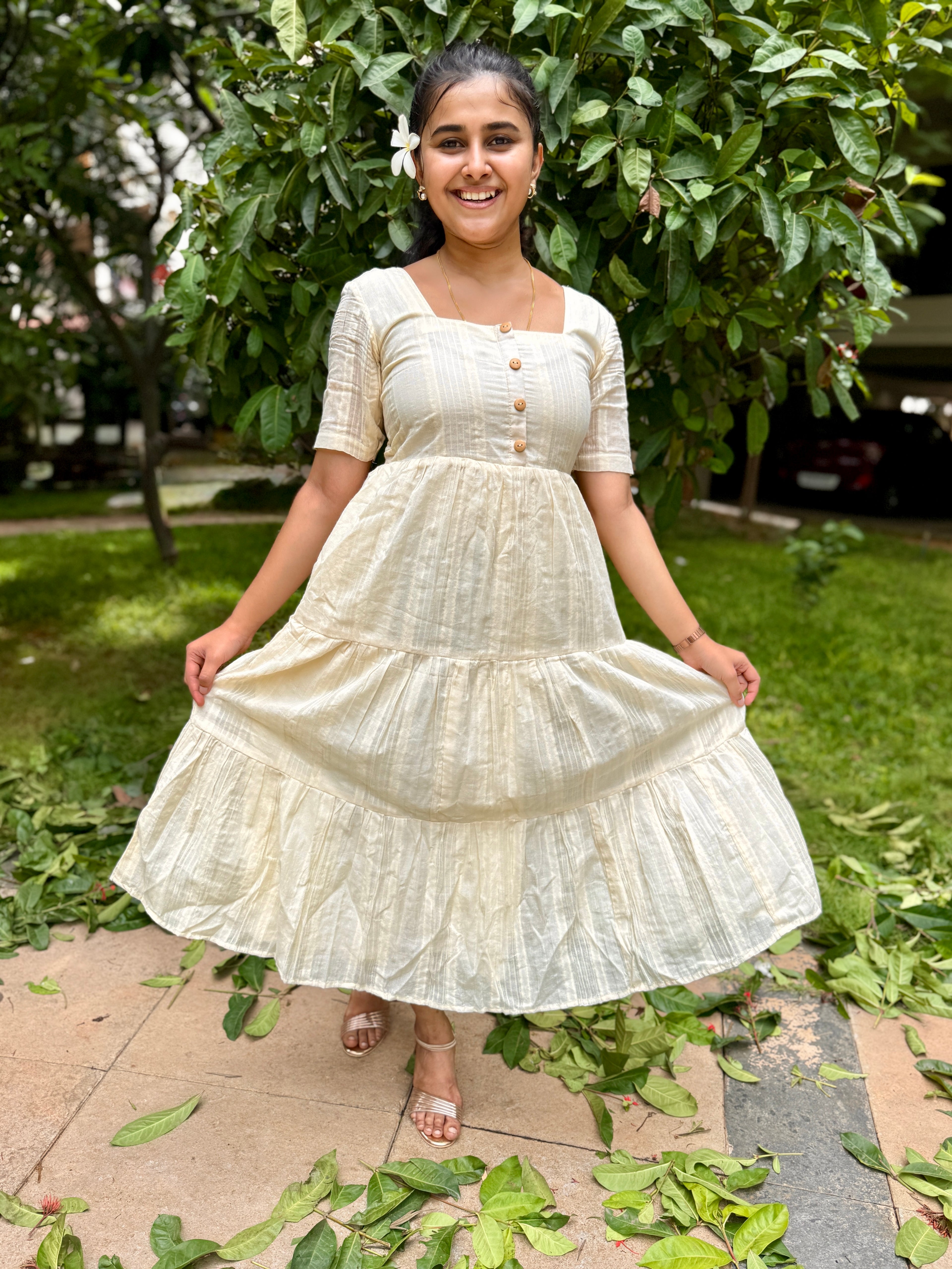 Model wearing Devrobes Vennila Velicham Dress – ivory cotton tiered maxi with soft flow and back tie detailing. Page maintained by Creations by Nash.