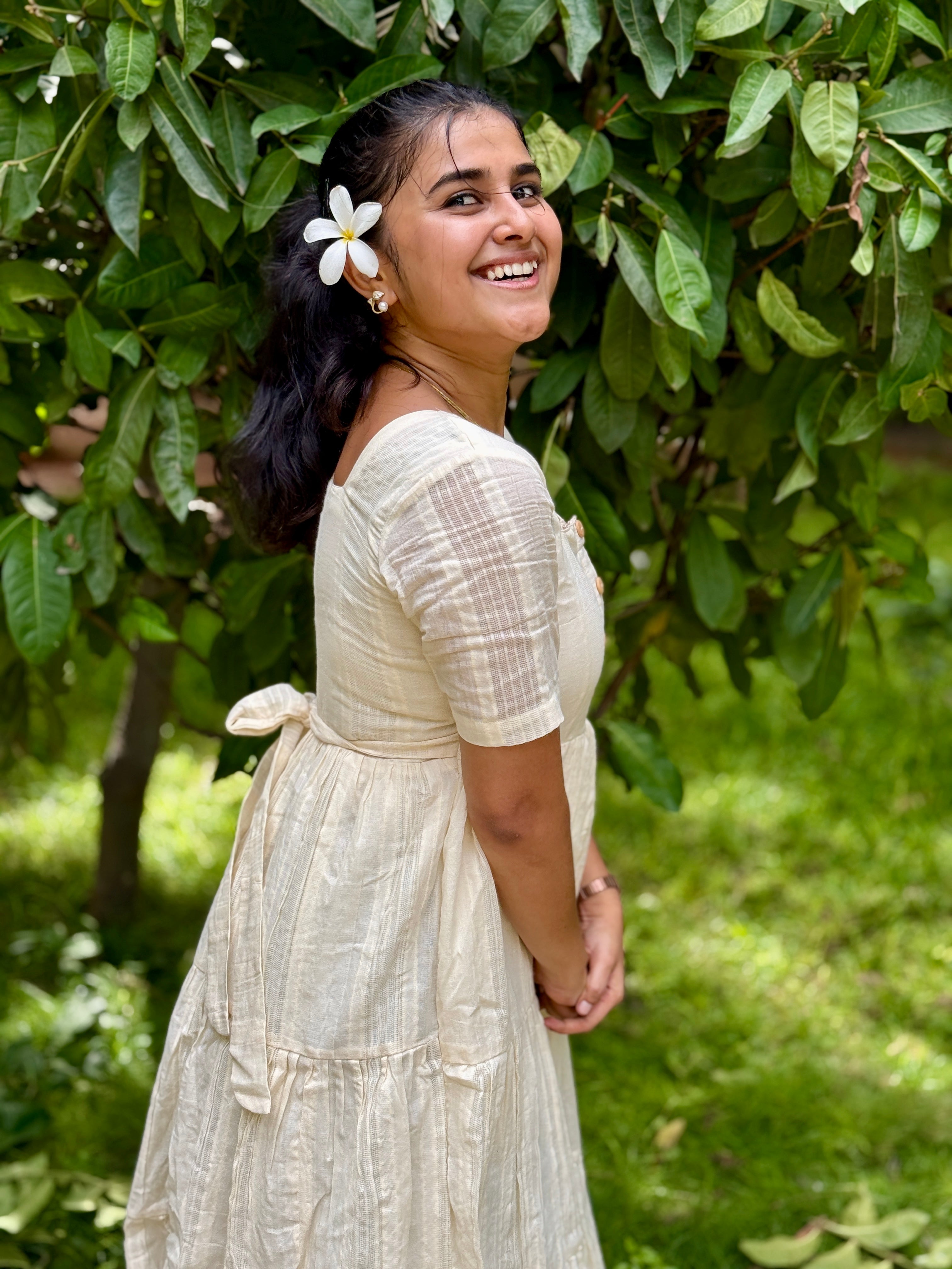 Model wearing Devrobes Vennila Velicham Dress – ivory cotton tiered maxi with soft flow and back tie detailing. Page maintained by Creations by Nash.
